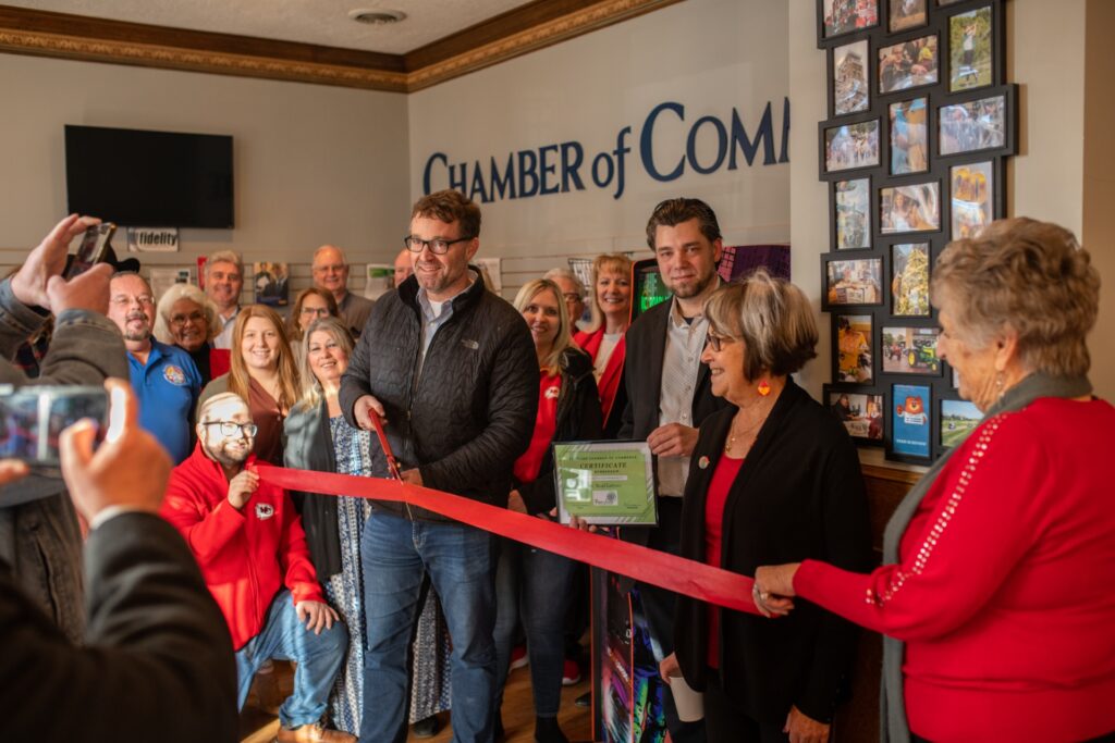 Attorney Chris Benjamin cuts a ribbon at the Harrisonville Area Chamber of Commerce.