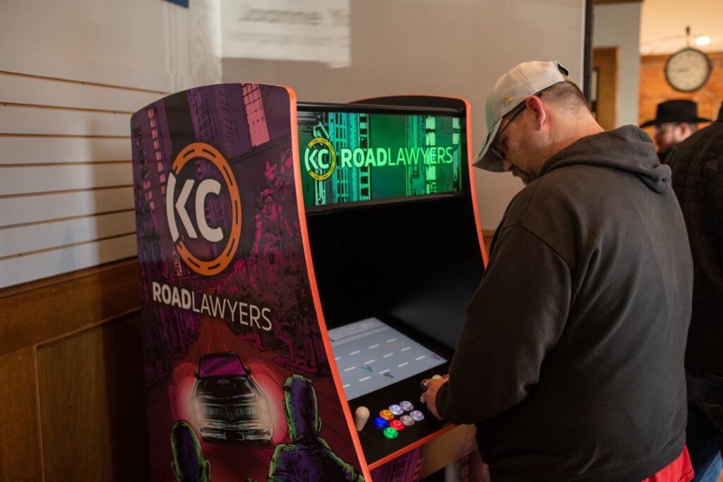 A man plays the KC Road Lawyer Arcade Game.