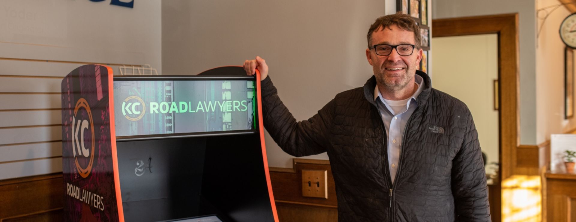 Attorney Chris Benjamin stands next to the KC Road Lawyer arcade Game.